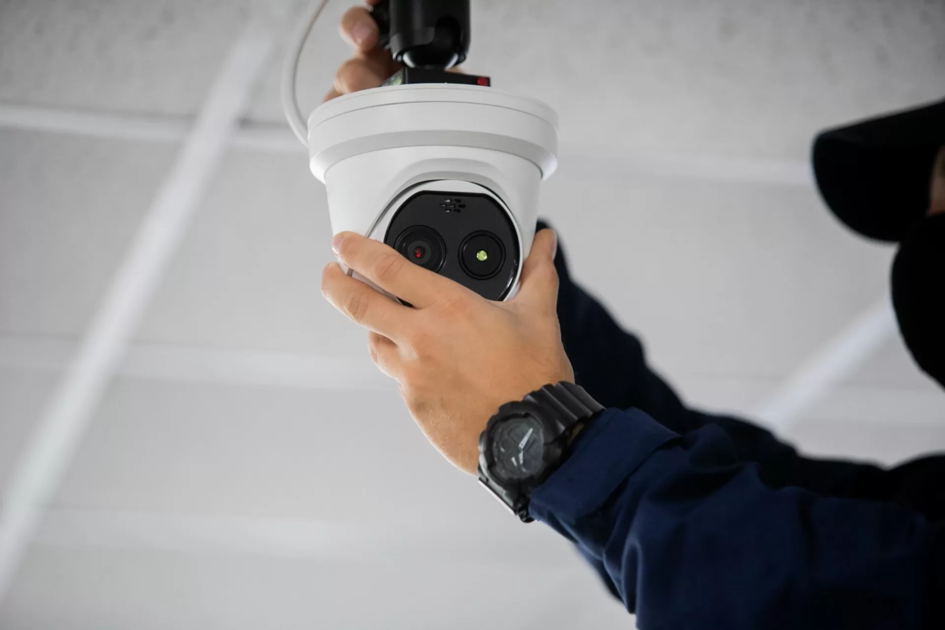Technician installing and servicing an outdoor CCTV camera